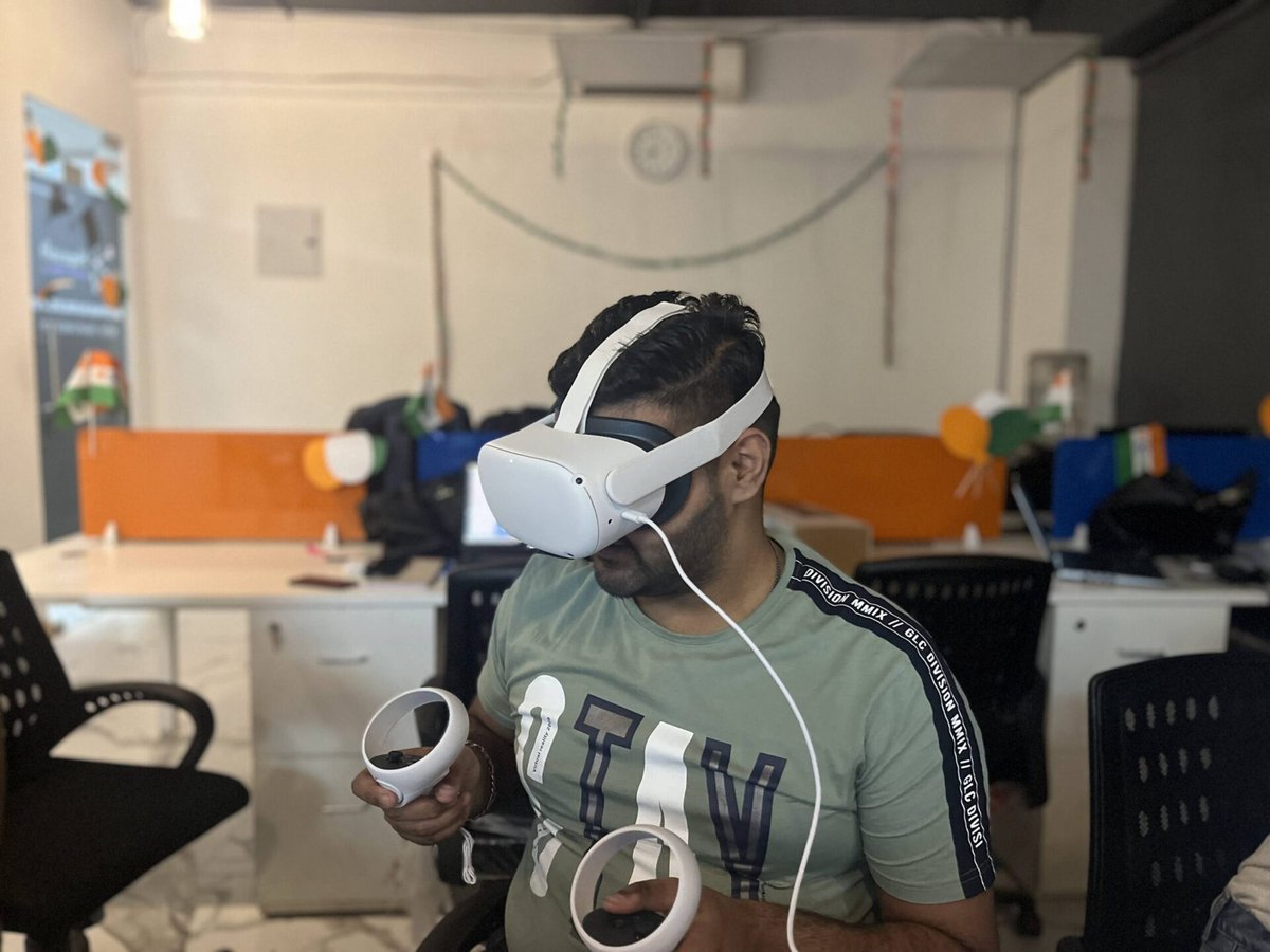 A HapzXR developer testing a VR simulation on a Meta Quest headset in the Noida studio